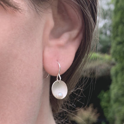 Kate Phipps Jewellery Domed circles drop earrings satin finish silver with white pearl model photo