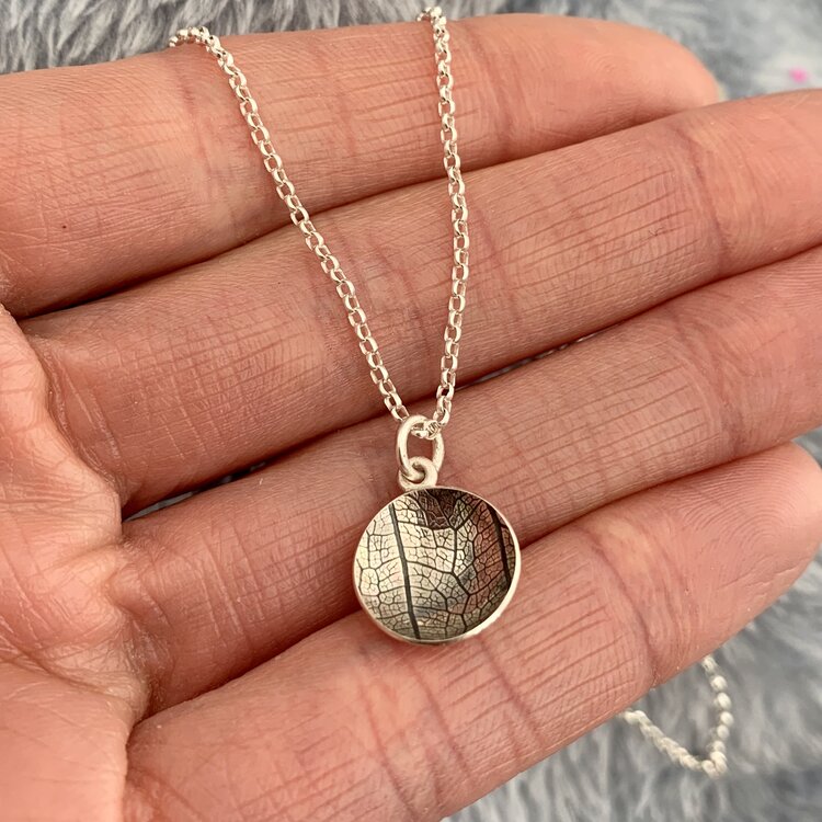 Kate Phipps Jewellery Domed circles necklace small 13mm reversible oxidised leaf skeleton texured silver on hand