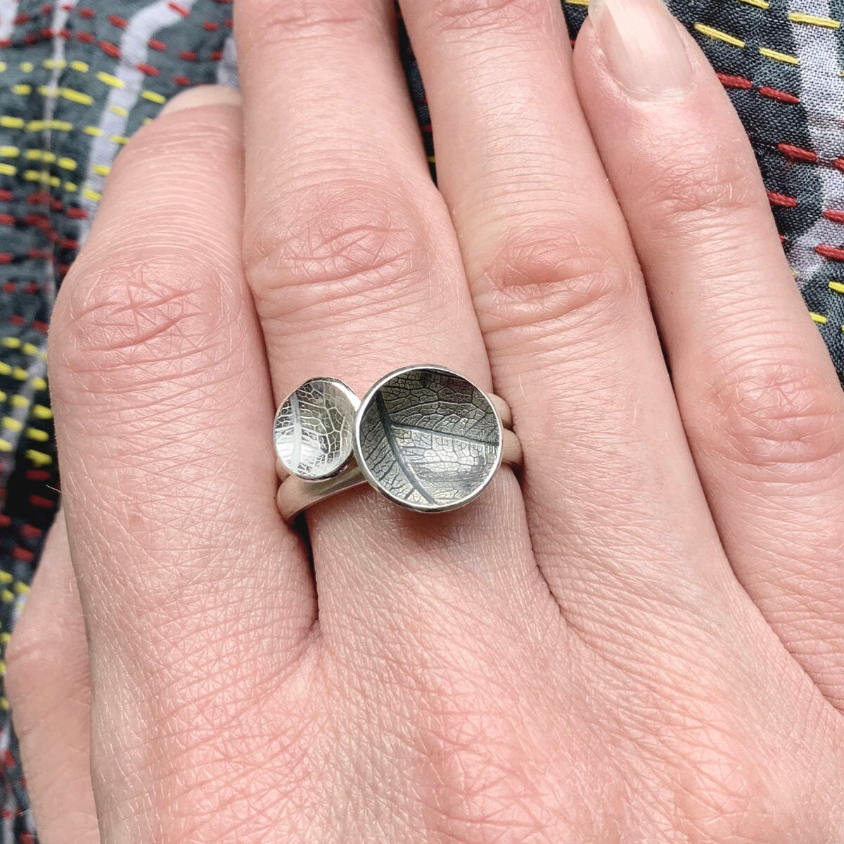 Kate Phipps Jewellery Domed circles ring large oxidised leaf skeleton textured silver stacked with mdium leaf skeleton textured silver ring model photo