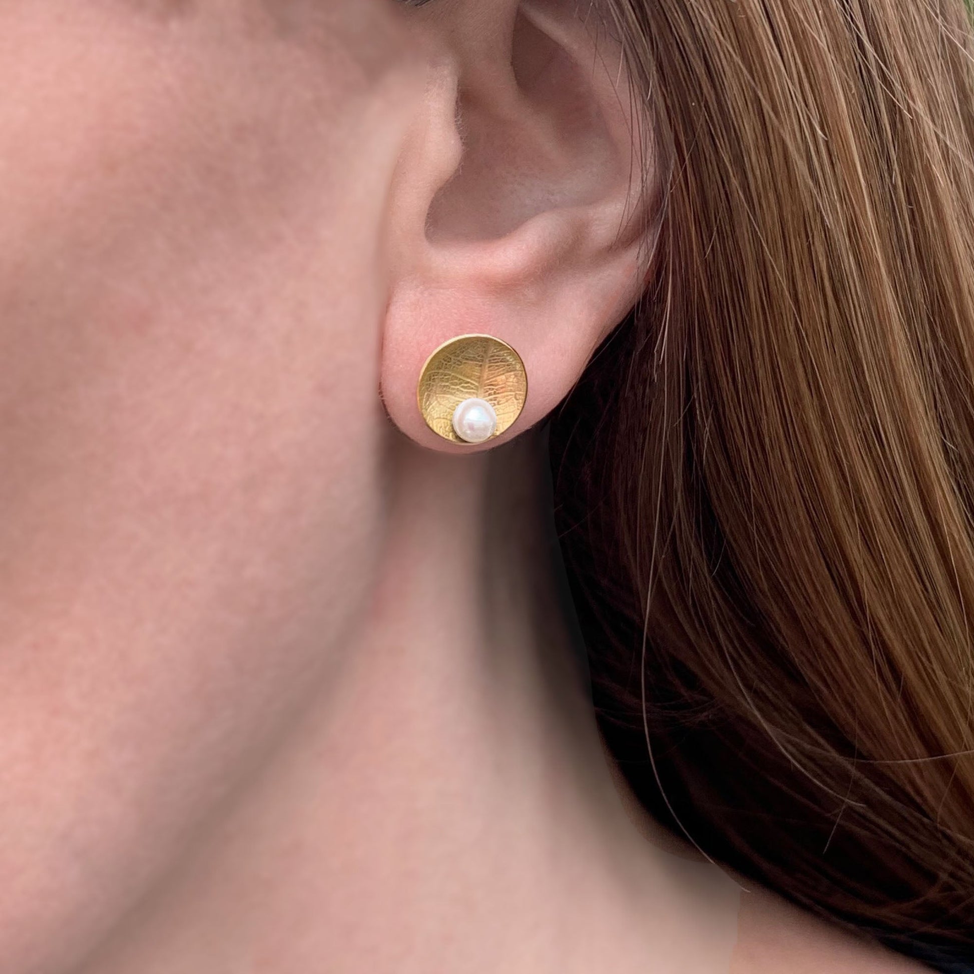 Kate Phipps Jewellery Domed circles stud earrings large 22 carat yellow gold plated silver leaf skeleton textured with white pearl model photo