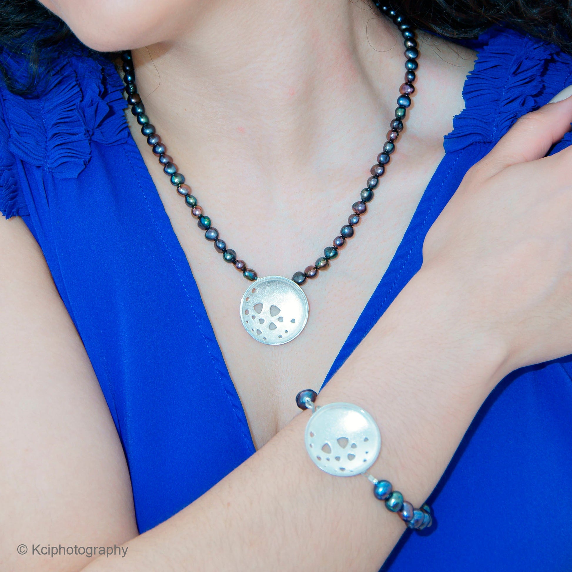 Kate Phipps Jewellery Scattered trillions necklace large silver pendant on peacock pearl beads and large silver bracelet on peacock pearl beads model photo 