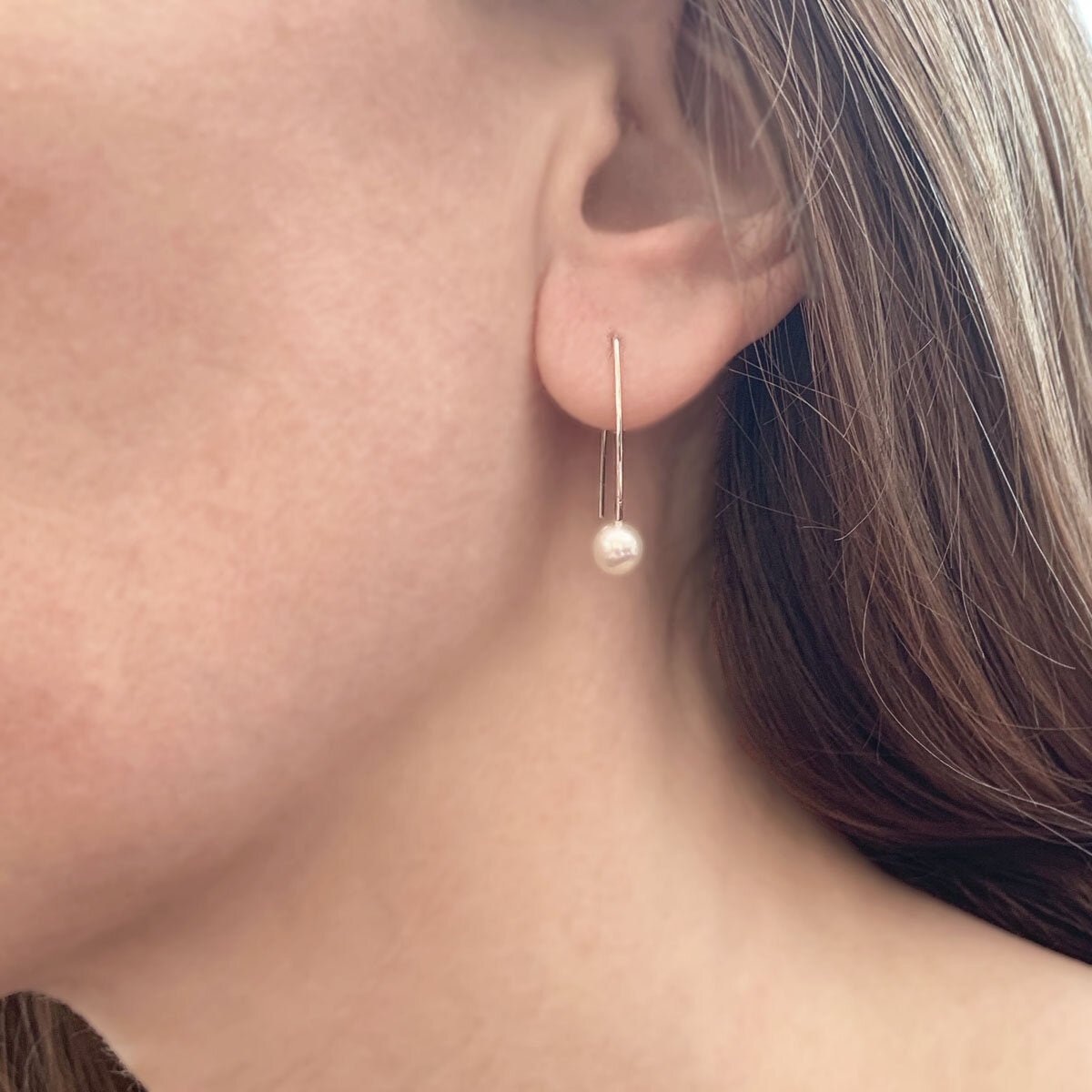 Kate Phipps Jewellery Simple elegance drop earrings long silver wire with white pearl model shot