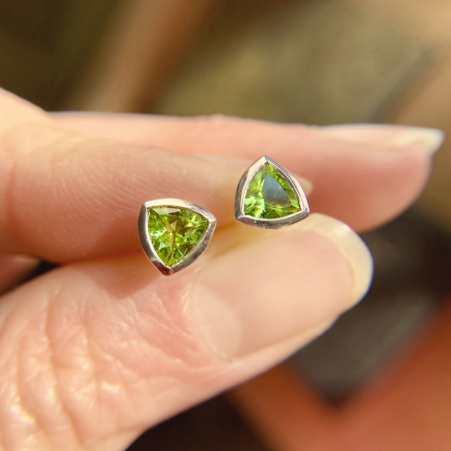 Kate Phipps Jewellery Single stone stud earrings silver with trillion cut peridot held in hand 2