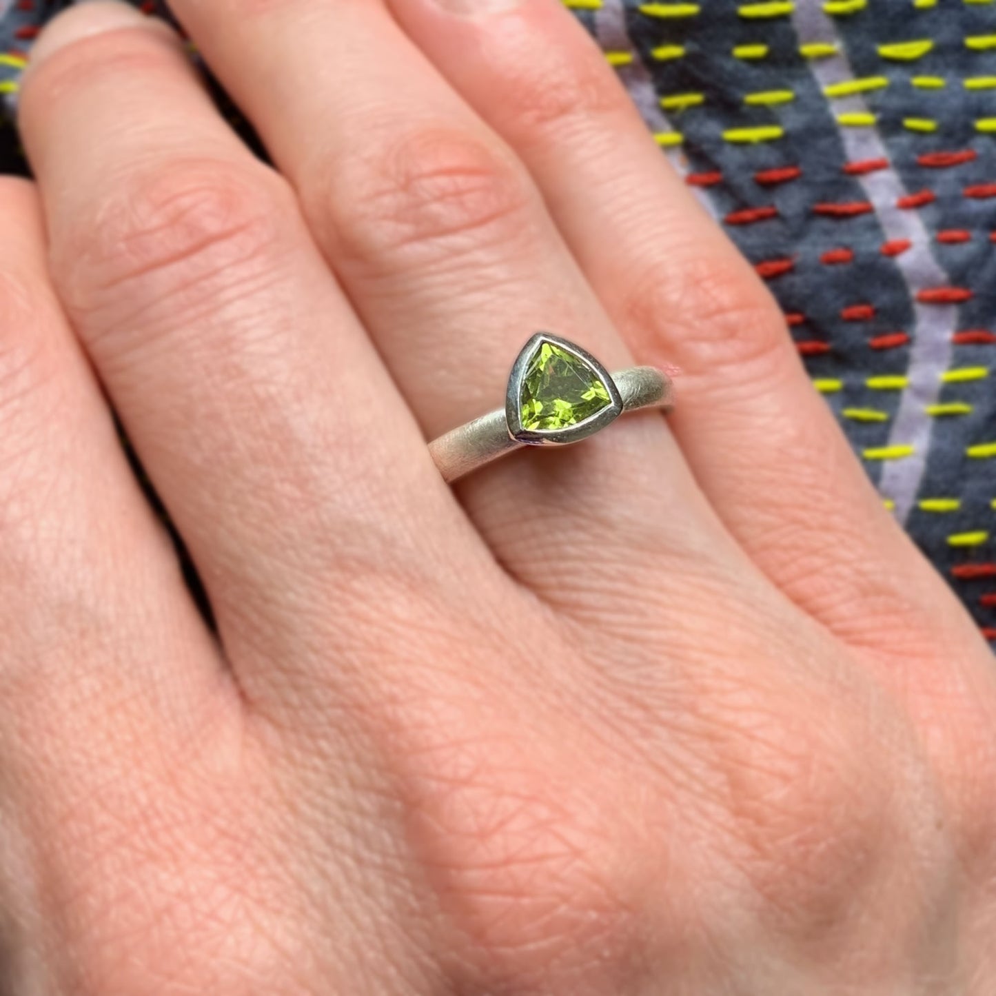 Kate Phipps Jewellery Solitaire ring 6mm trillion cut peridot on oval silver ring band model photo