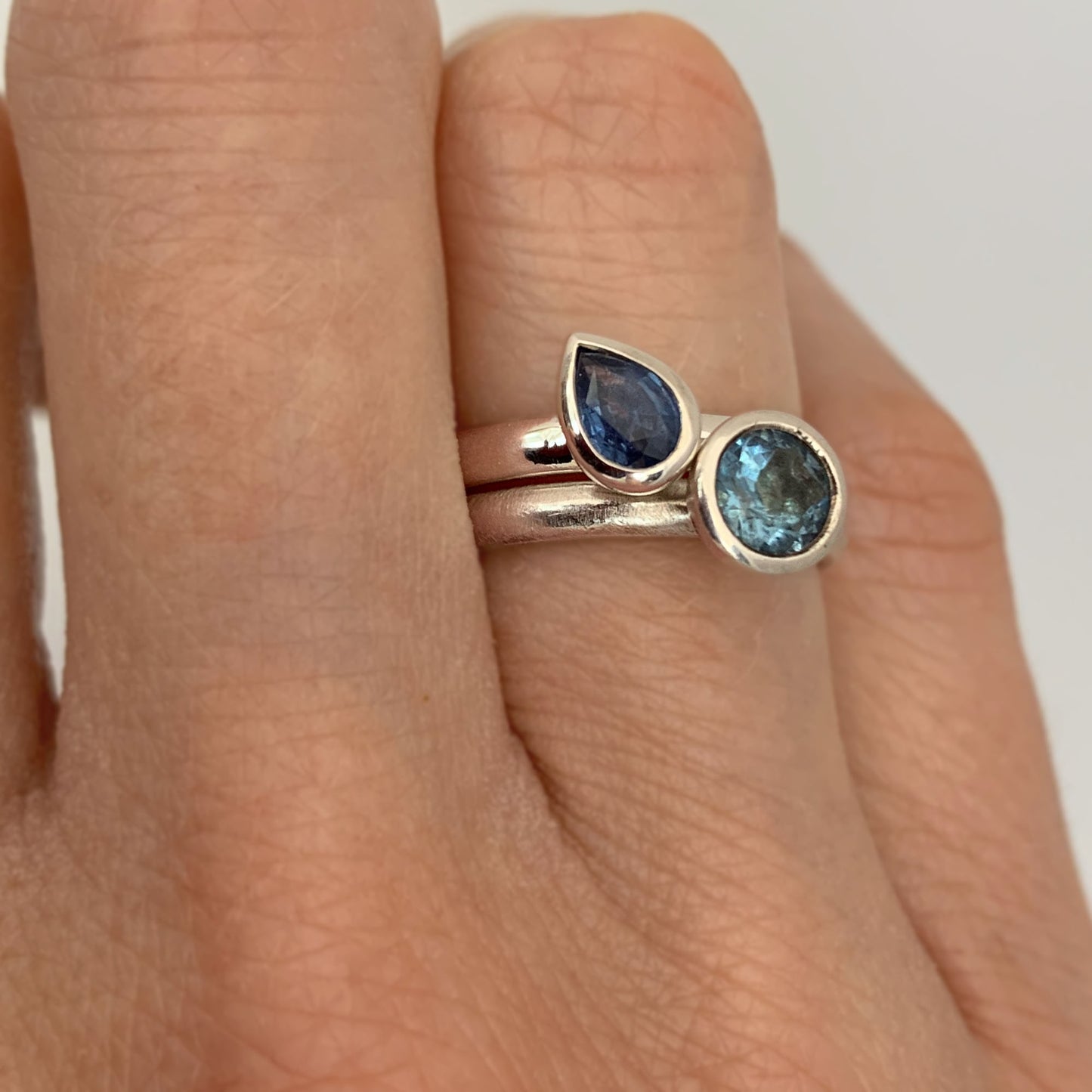 Kate Phipps Jewellery Solitaire ring pear blue sapphire in silver and scattered trillions sky blue topaz and silver model  photo