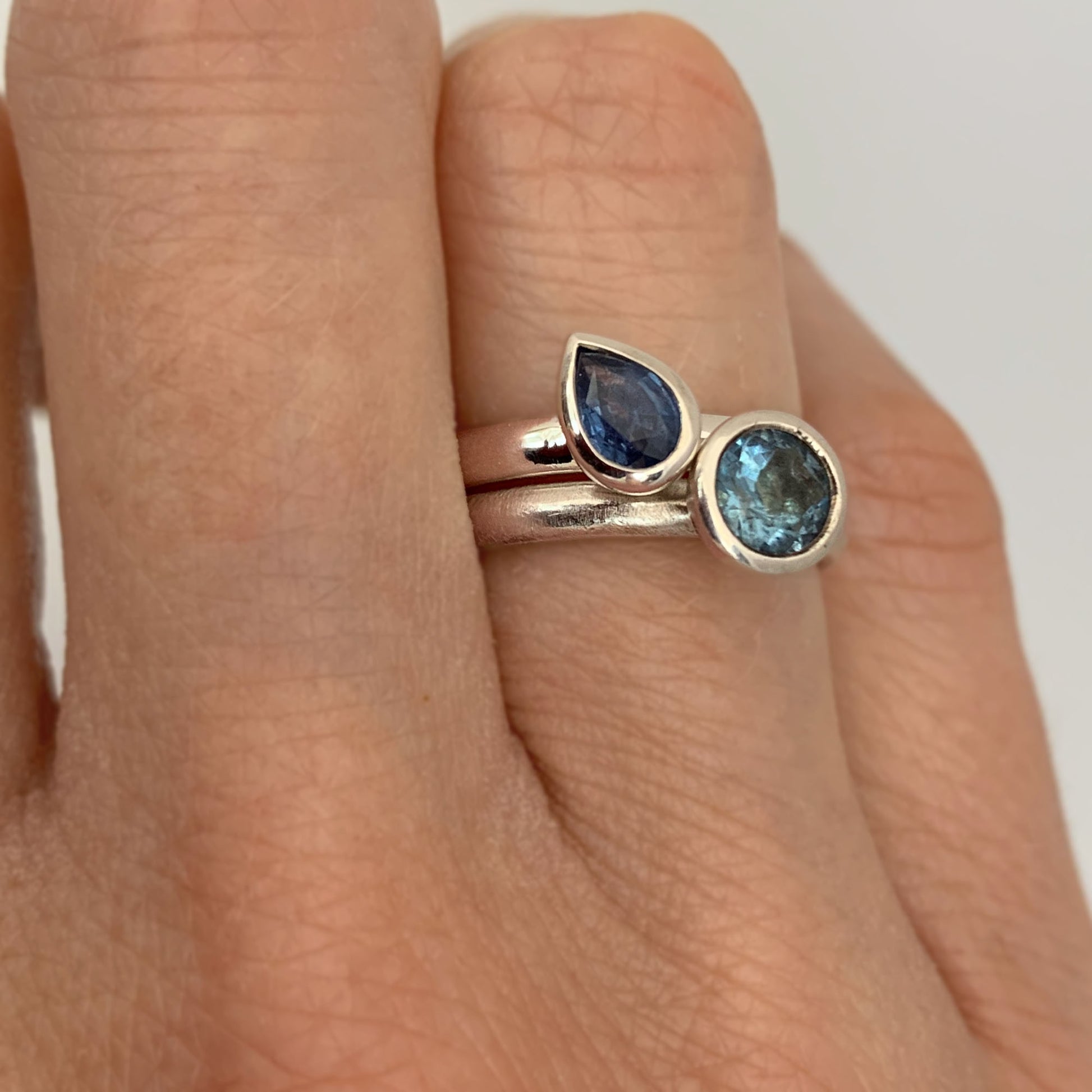 Kate Phipps Jewellery Solitaire ring pear blue sapphire in silver and scattered trillions sky blue topaz and silver model  photo