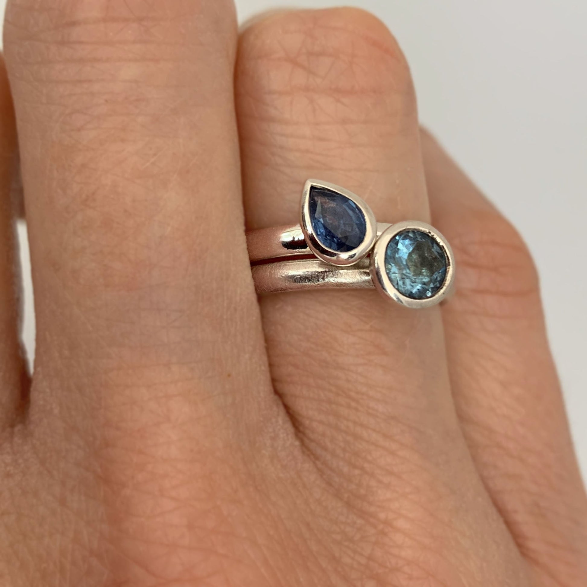 Kate Phipps Jewellery Solitaire ring pear blue sapphire in silver and scattered trillions sky blue topaz and silver model  photo