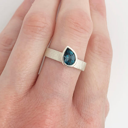 Kate Phipps Jewellery Solitaire ring pear darker London blue topaz offset on silver ring band model photo 1
