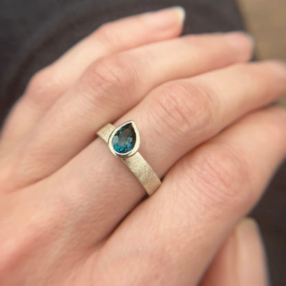 Kate Phipps Jewellery Solitaire ring pear darker London blue topaz offset on silver ring band model photo 2