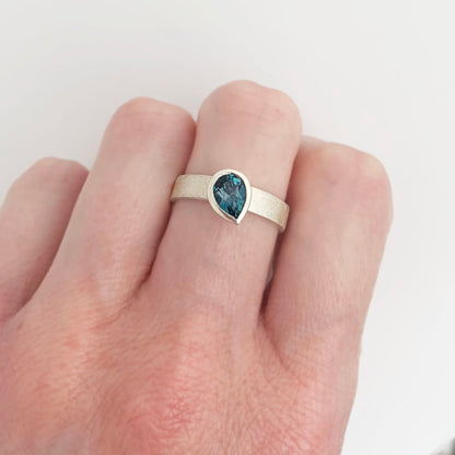 Kate Phipps Jewellery Solitaire ring pear darker London blue topaz offset on silver ring band model photo 3
