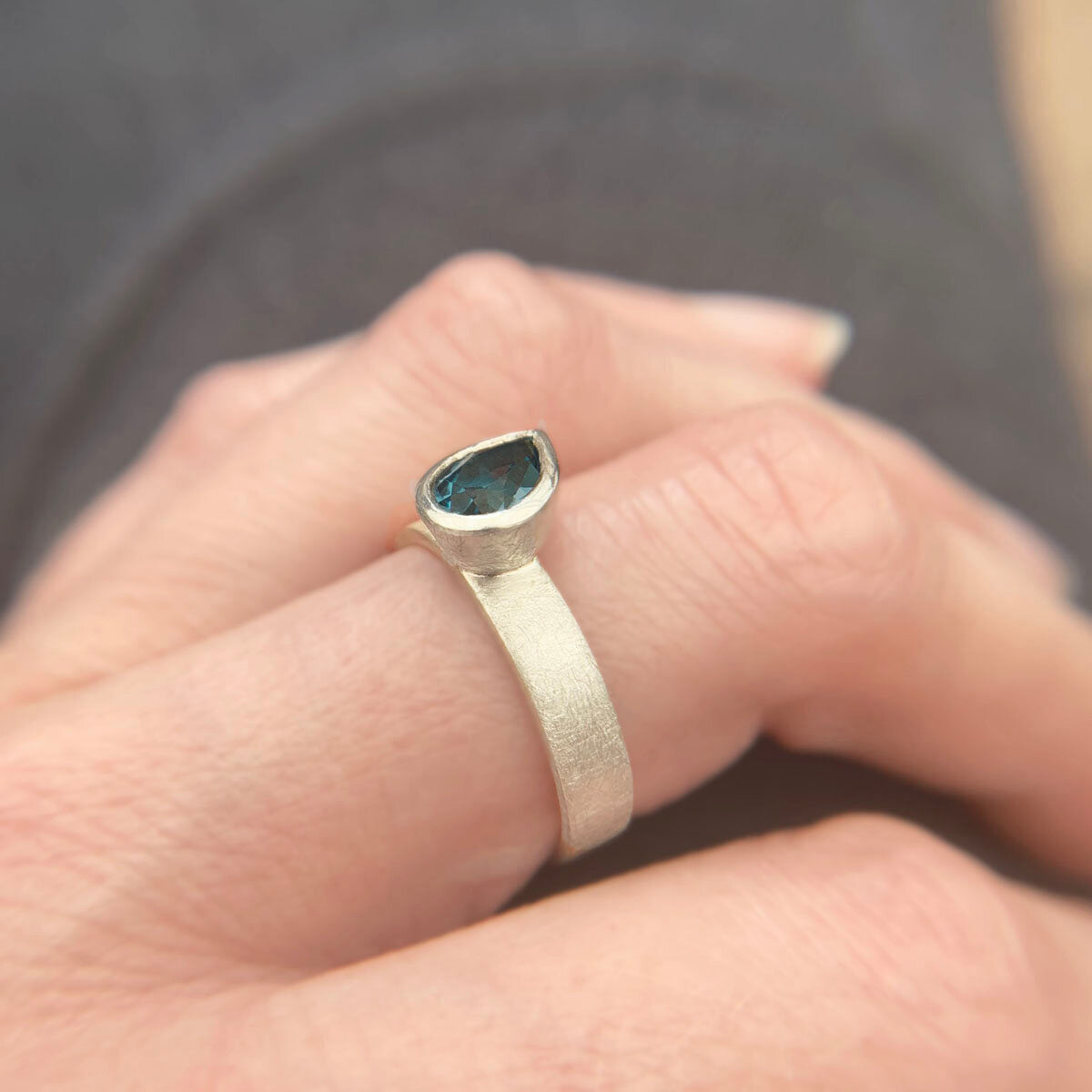 Kate Phipps Jewellery Solitaire ring pear darker London blue topaz offset on silver ring band model photo 4