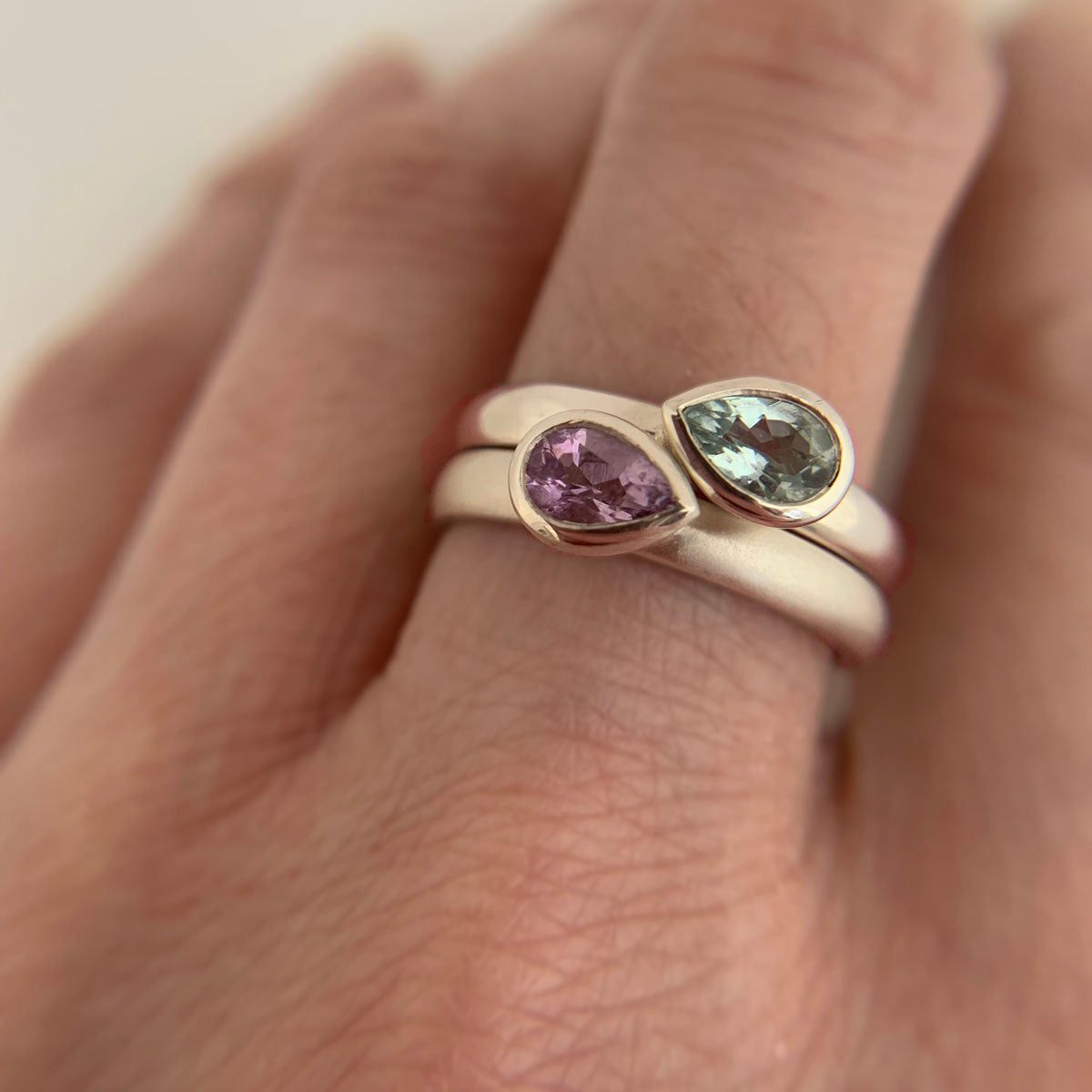 Kate Phipps Jewellery Stacking ring pair silver with pear shaped green beryl and pale amethyst pointing opposite directions points closer together model photo