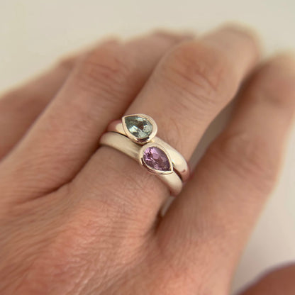Kate Phipps Jewellery Stacking ring pair silver with pear shaped green beryl and pale amethyst pointing opposite directions points further away model photo