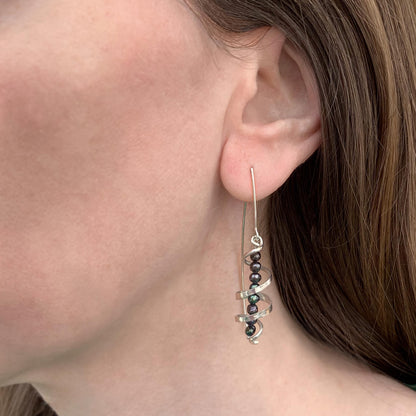 Kate Phipps Jewellery silver swirl and peacock pearl drop earrings model photo