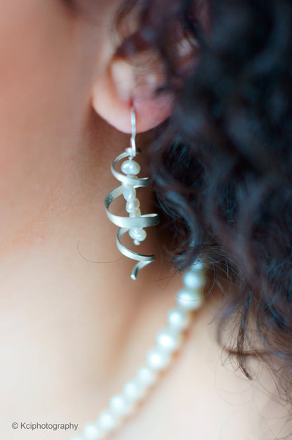 Kate Phipps Jewellery silver swirl and white pearl drop earrings model photo