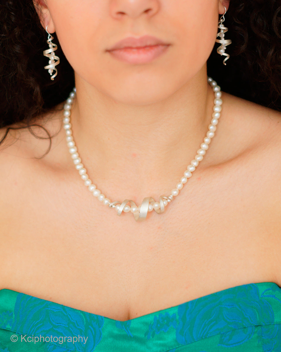 Kate Phipps Jewellery silver swirl and white pearl necklace and drop earrings model photo