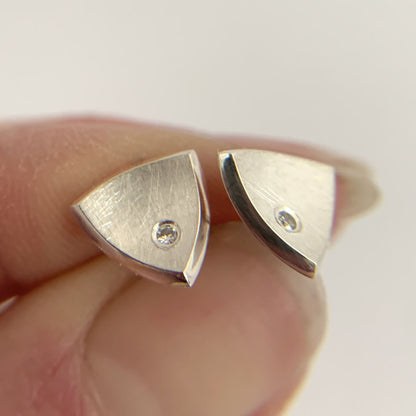 Kate Phipps Jewellery Trillion stud earrings medium silver with flush set diamonds held in hand